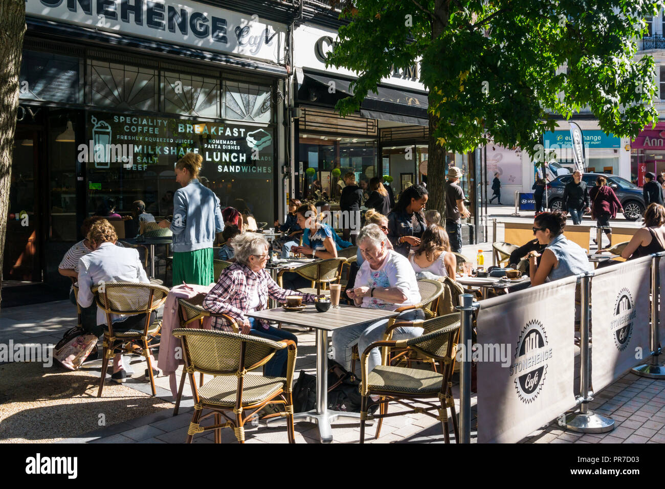 La gente seduta nella luce del sole in un cafe' sul marciapiede a Bromley Piazza del Mercato. Foto Stock