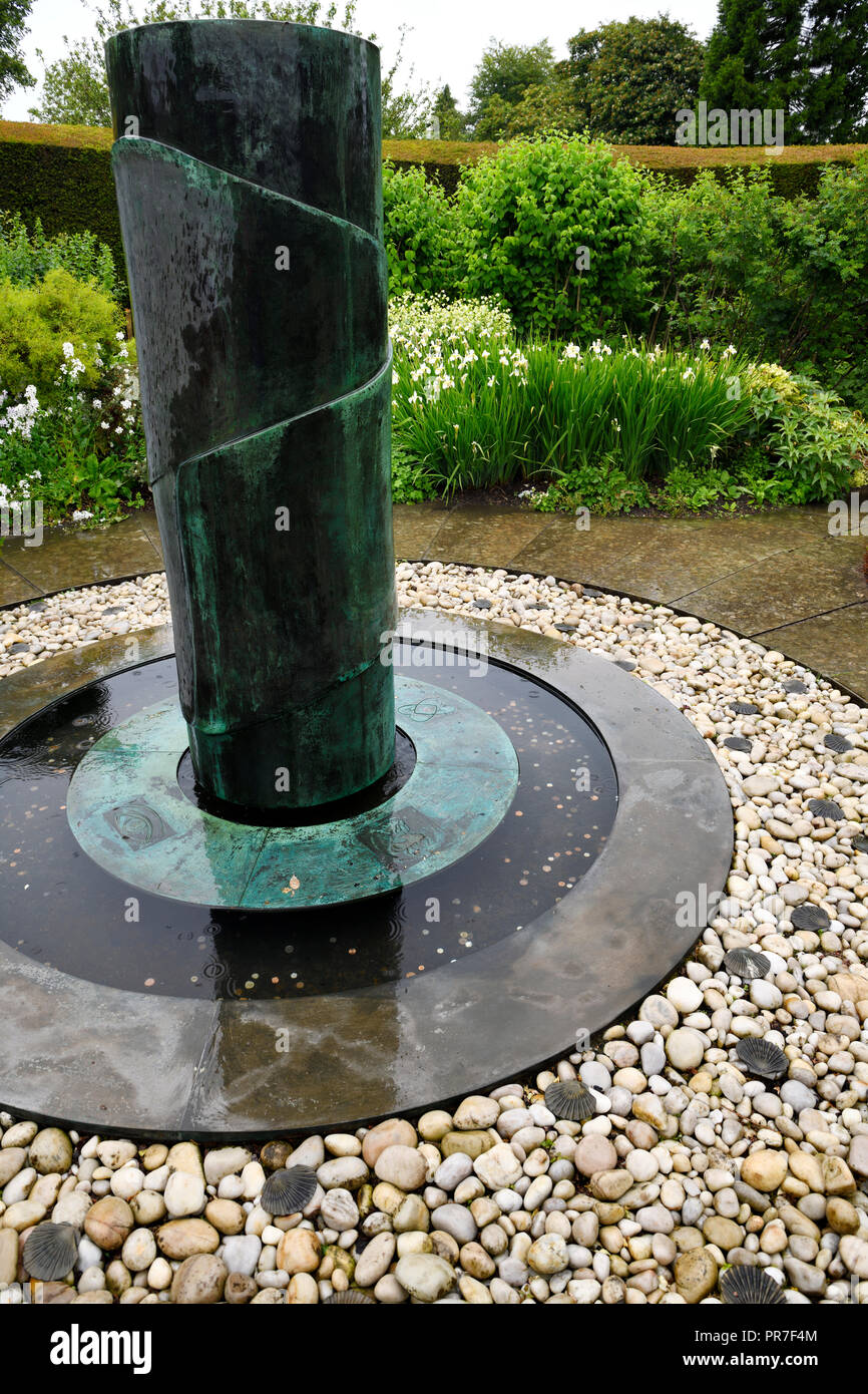 Fontana in bronzo nel Giardino del Paradiso del giardino murato a Cawdor Castle con fiori di colore bianco in pioggia Scotland Regno Unito Foto Stock
