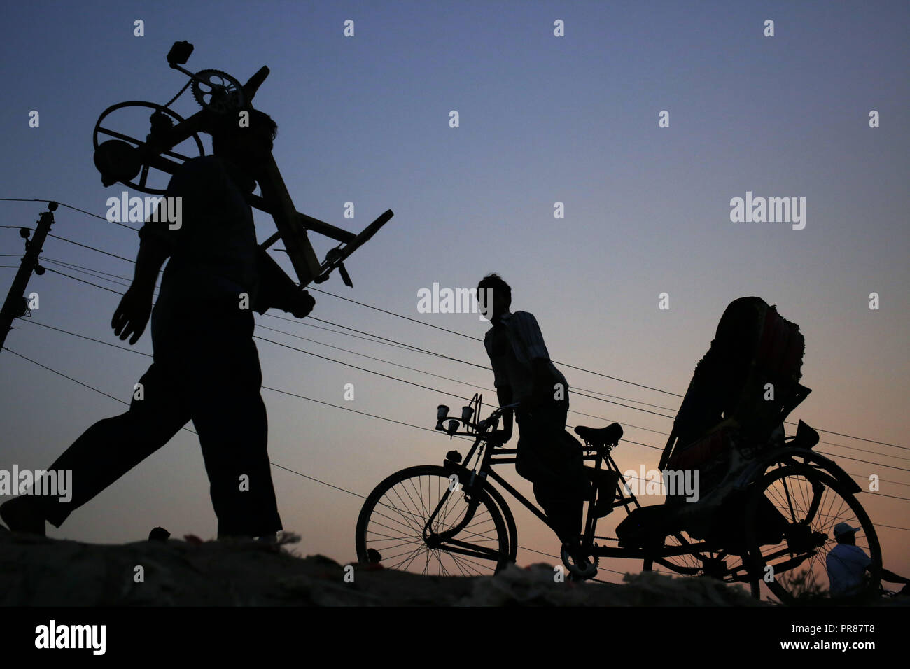 Dacca in Bangladesh. Il 30 settembre, 2018. Un coltello mutuante e risciò silhouette dell'estrattore contro il sole come tornano a casa dal lavoro in emarginati di Gabtoli, un quartiere di Dhaka. Credito: MD Mehedi Hasan/ZUMA filo/Alamy Live News Foto Stock