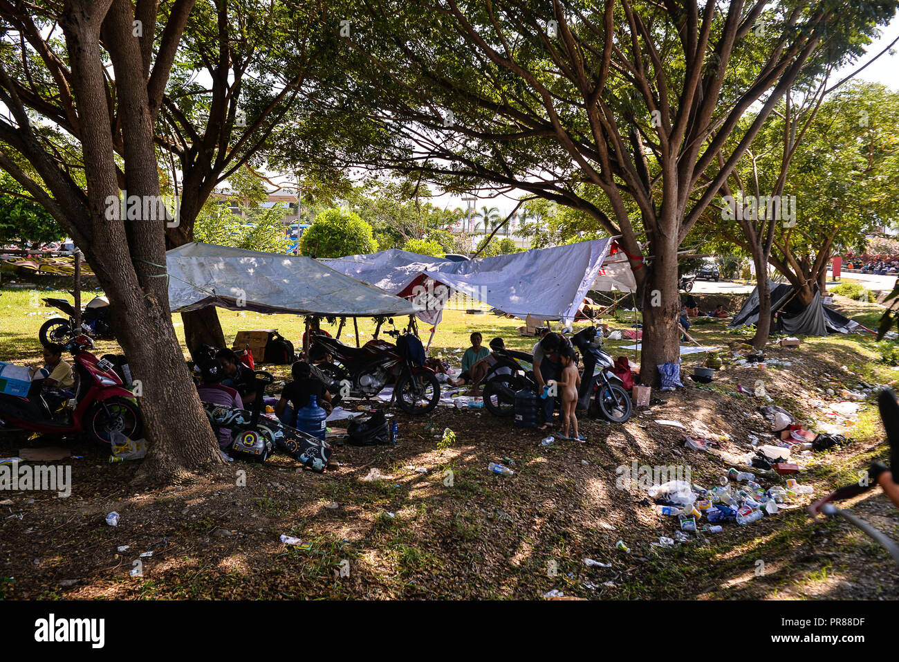 Palu. Il 30 settembre, 2018. Foto scattata il 7 settembre 30, 2018 mostra le persone a un fare-shift shelter a Palu nella centrale provincia di Sulawesi, Indonesia. Numero di morti dall'Indonesia il forte terremoto e tsunami in Sulawesi centrale provincia sono saliti a 832 Domenica, come la mancanza di soccorritori e grandi aree colpite restanti difficile accesso ostacolato sforzi di ricerca e salvataggio, un funzionario governativo ha detto qui. Credito: Iqbal Lubis/Xinhua/Alamy Live News Foto Stock
