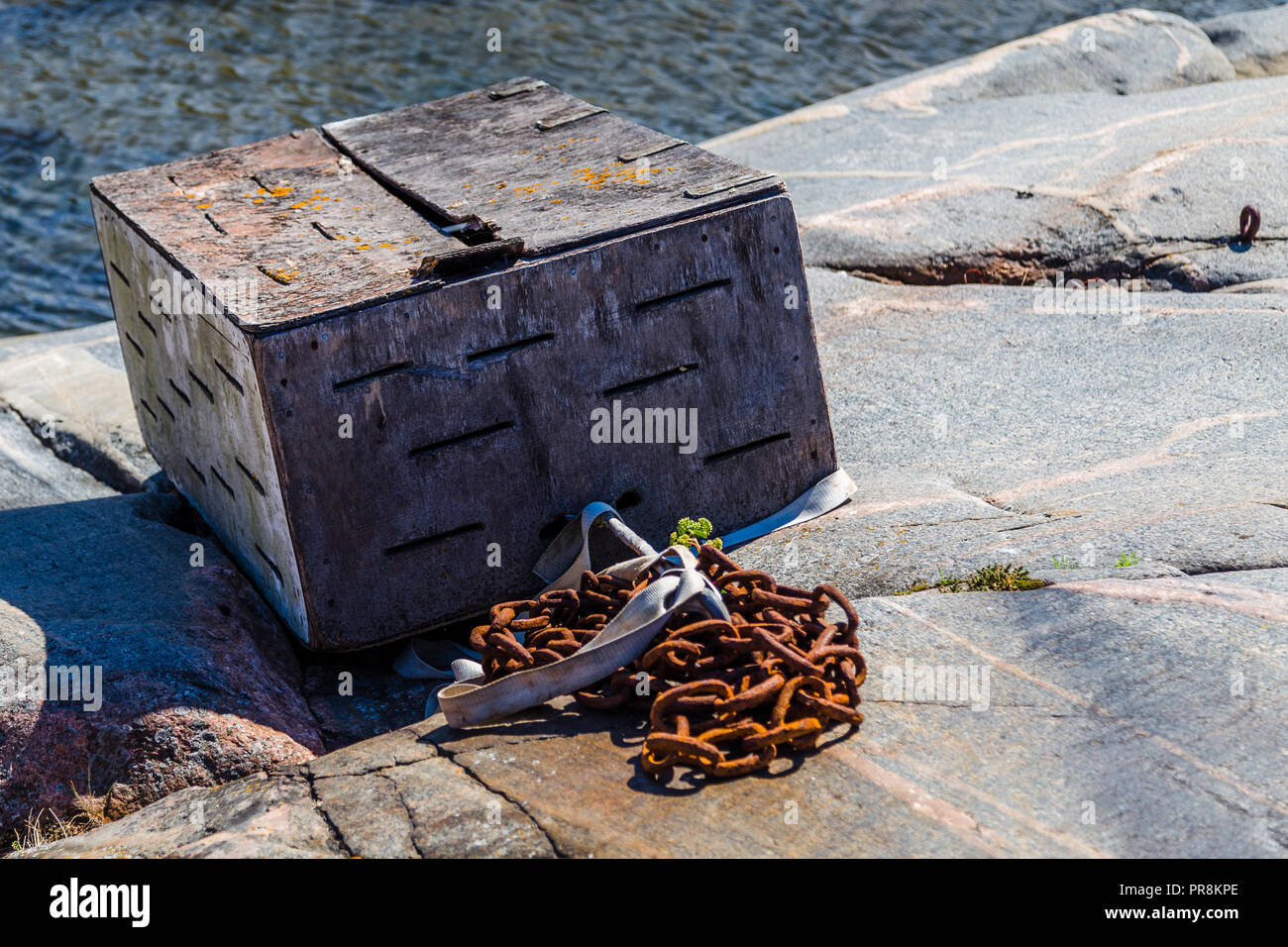 Misteriosa vecchia scatola di legno incatenato alla scogliera di Hanko in Finlandia Foto Stock