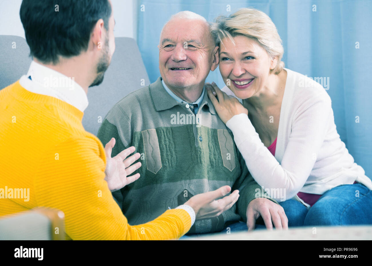 Età nonno e sua figlia comunicare calorosamente con il nipote a casa Foto Stock
