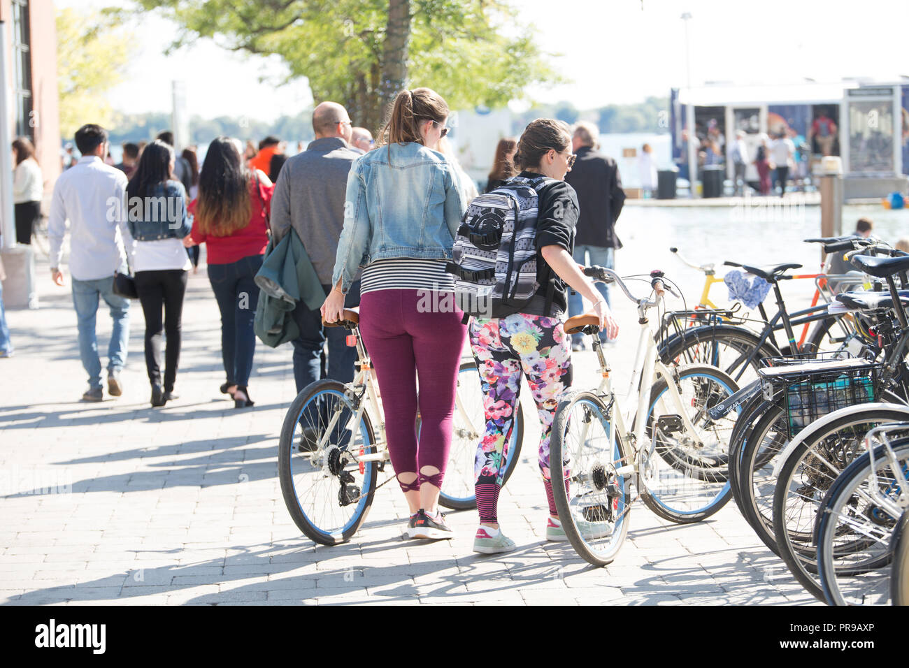 Due donne che si muovono di moto-bici Foto Stock