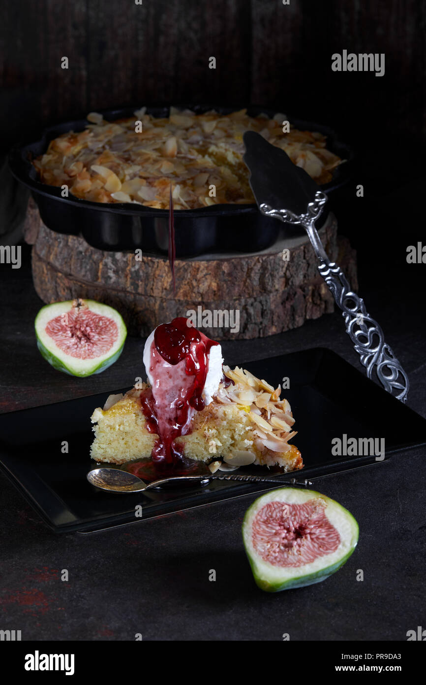 Torta di fichi con scaglie di mandorle e gelato alla vaniglia con salsa di gocciolamento. Foto Stock