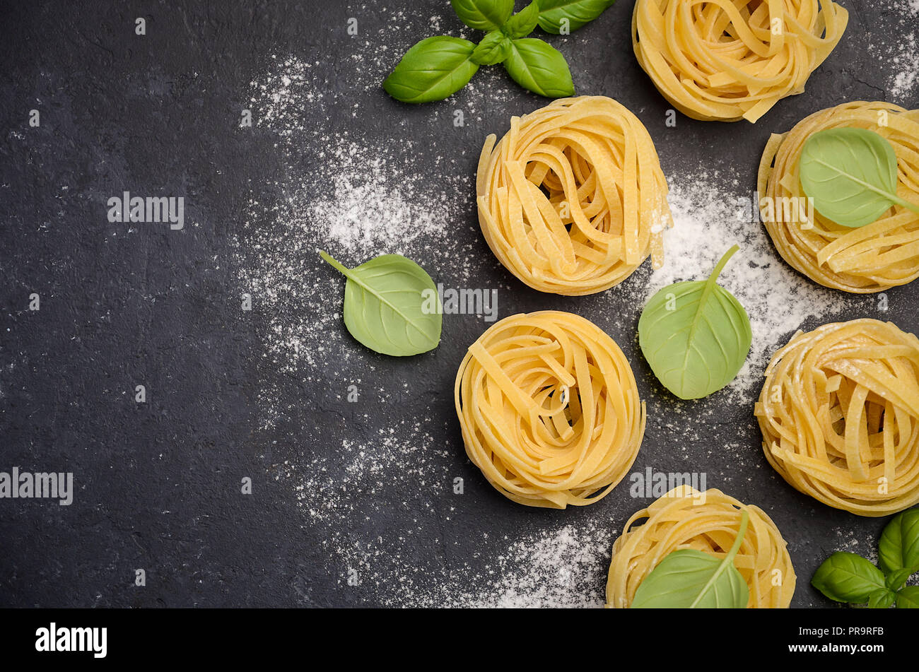 Materie tagliatelle sul nero lo sfondo di calcestruzzo Foto Stock