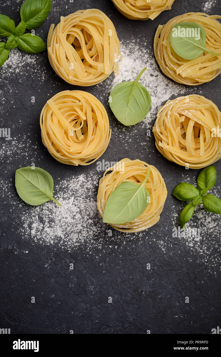 Materie tagliatelle sul nero lo sfondo di calcestruzzo Foto Stock
