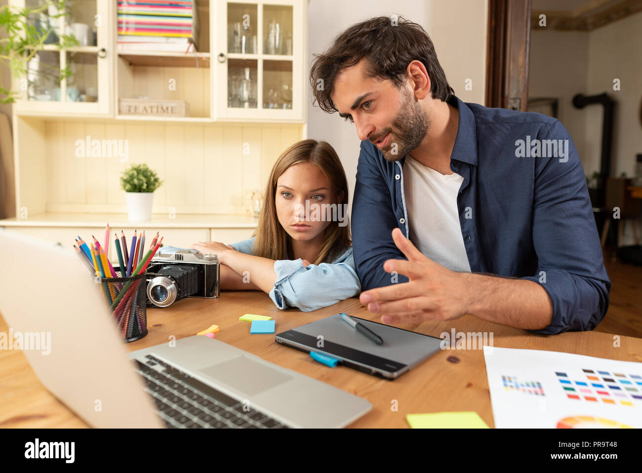 Graphic Designer parlare del progetto, la progettazione e il disegno al computer, lavorare a casa, freelancer il brainstorming Foto Stock