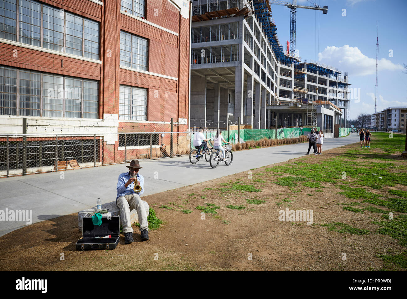 Atlanta capitale della condizione degli Stati Uniti della Georgia, la gente la bicicletta su una passerella con un uomo in primo piano a suonare la tromba Foto Stock