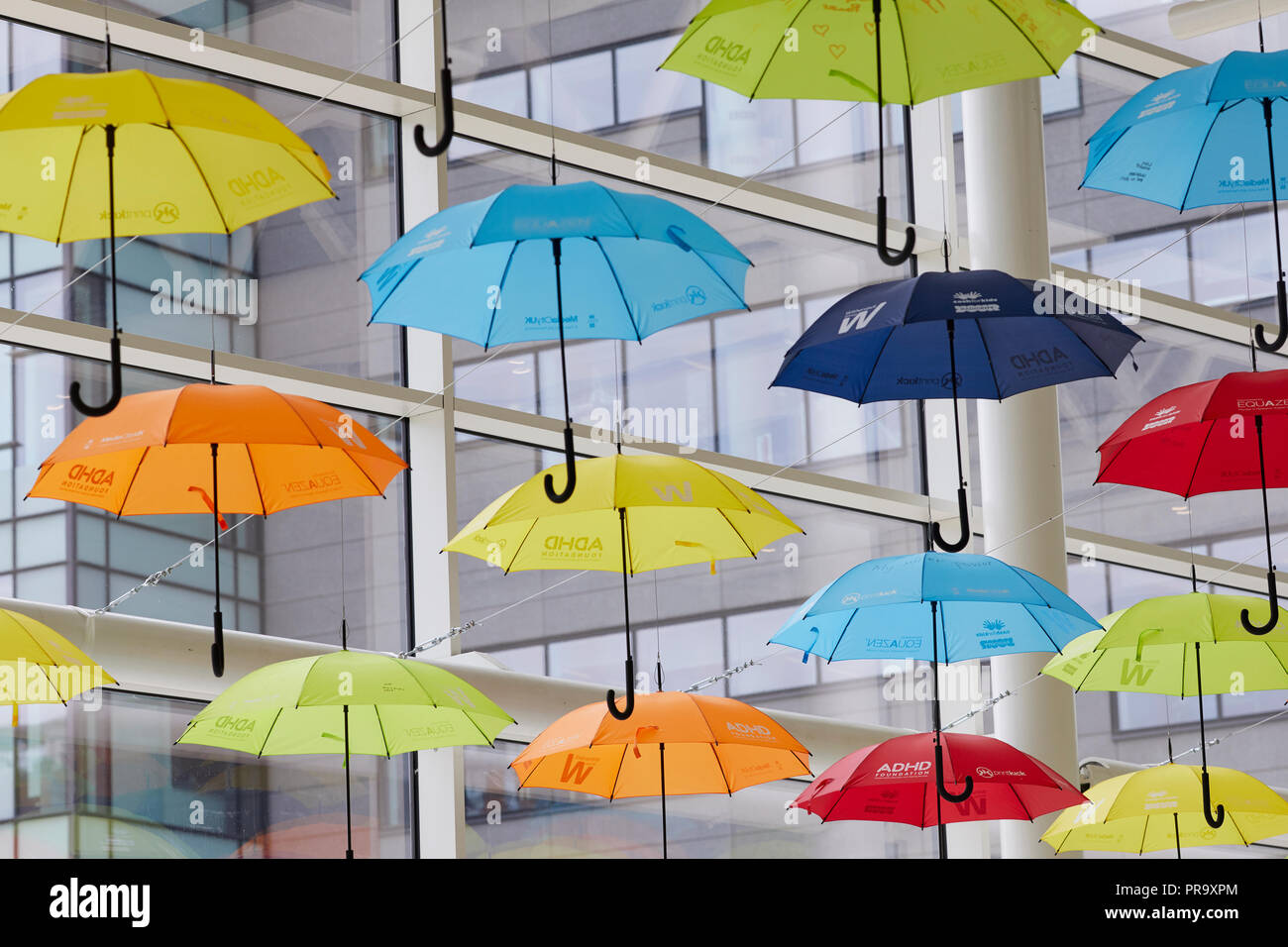 Vivacemente colorato ombrelloni sospesi in MediaCityUK Salford Quays per aumentare la consapevolezza del Disturbo da Deficit di Attenzione e Iperattività (ADHD) e l'autismo Foto Stock