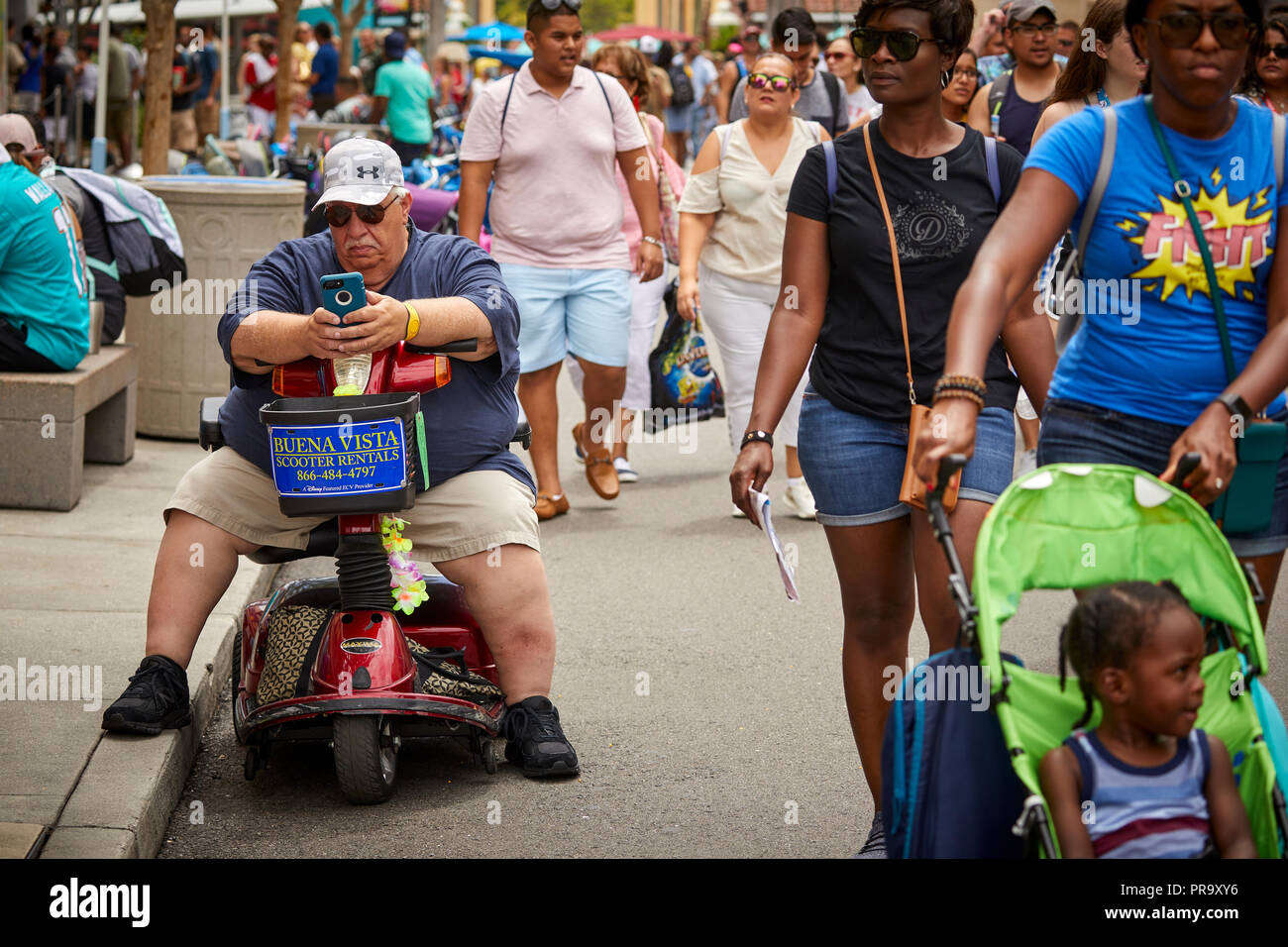 Uomo di grandi dimensioni su uno scooter dentro gli Universal Studios Orlando in Florida Foto Stock