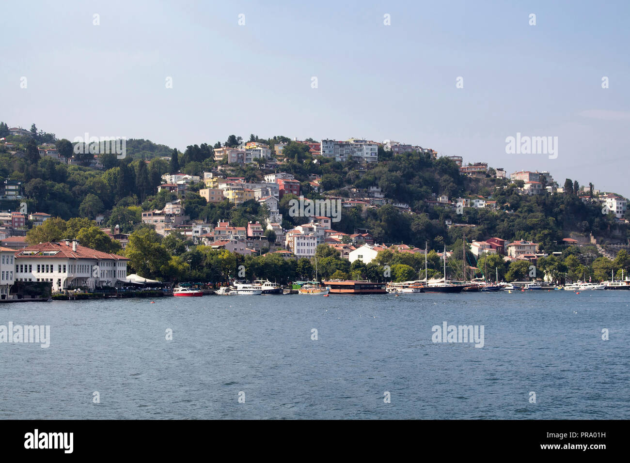 Vista delle barche e yacht, sul Bosforo, edifici in Kurucesme quartiere sul lato Europeo di Istanbul. È una soleggiata giornata estiva. Foto Stock