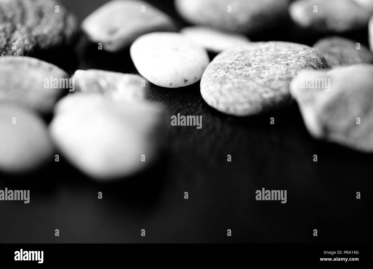 Pietre sparse su uno sfondo scuro vicino. In bianco e nero Foto Stock