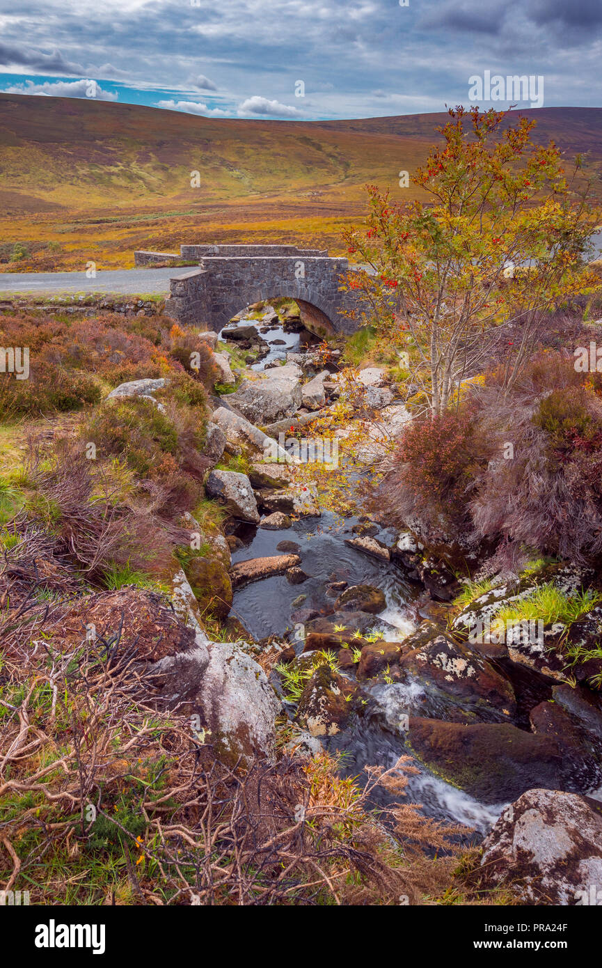 Un antico ponte in pietra che attraversa un fiume in Wicklow Mountains, Irlanda - molte scene di film sono stati girati qui Foto Stock