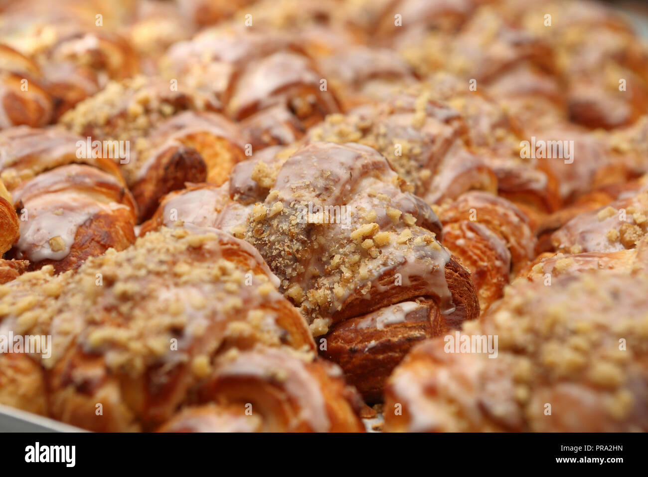 Croissant fresco con i dadi in panetteria di metallo sul vassoio antigoccia sfondo Foto Stock