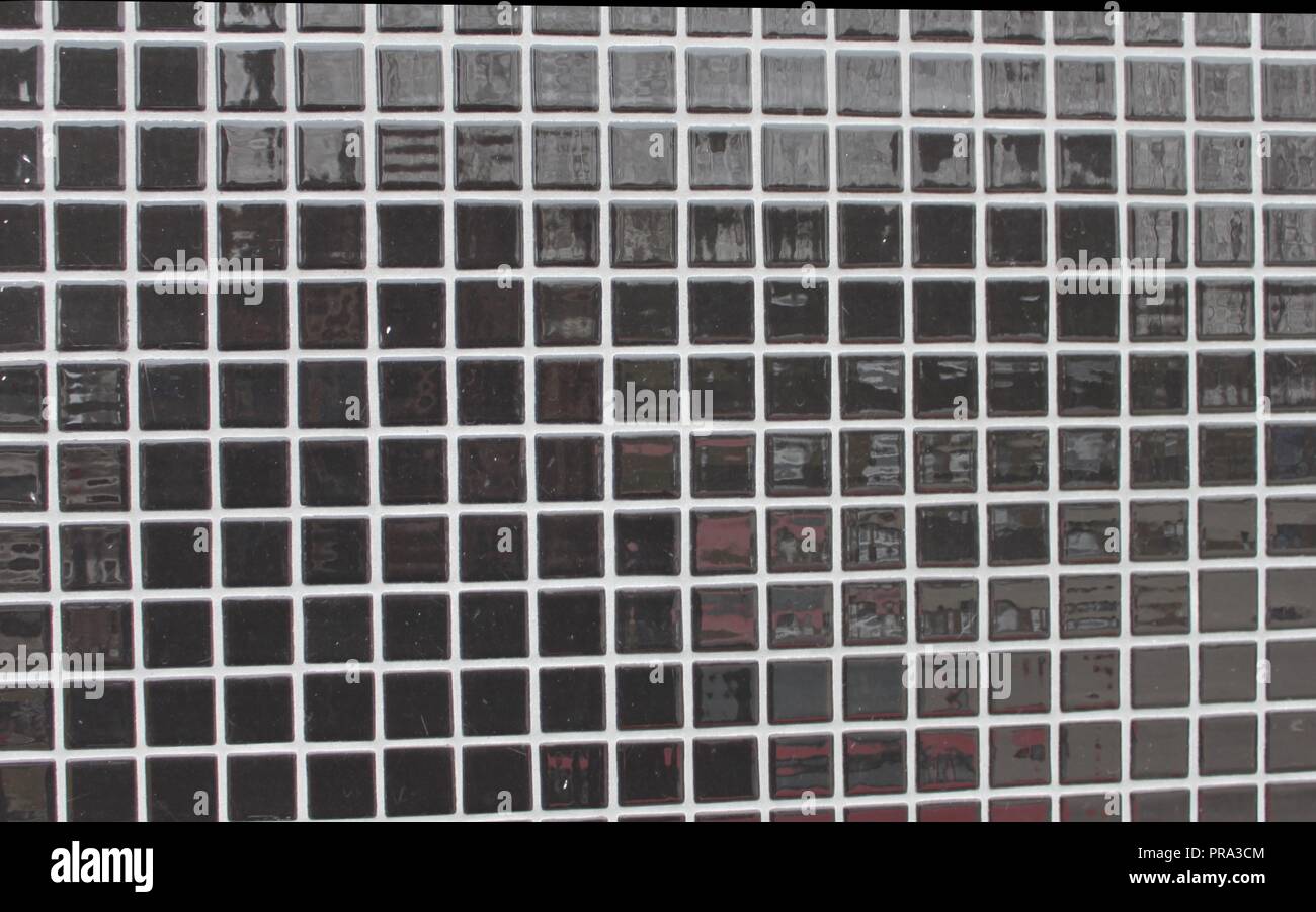 Il nero di piastrelle a mosaico su una parete Foto Stock