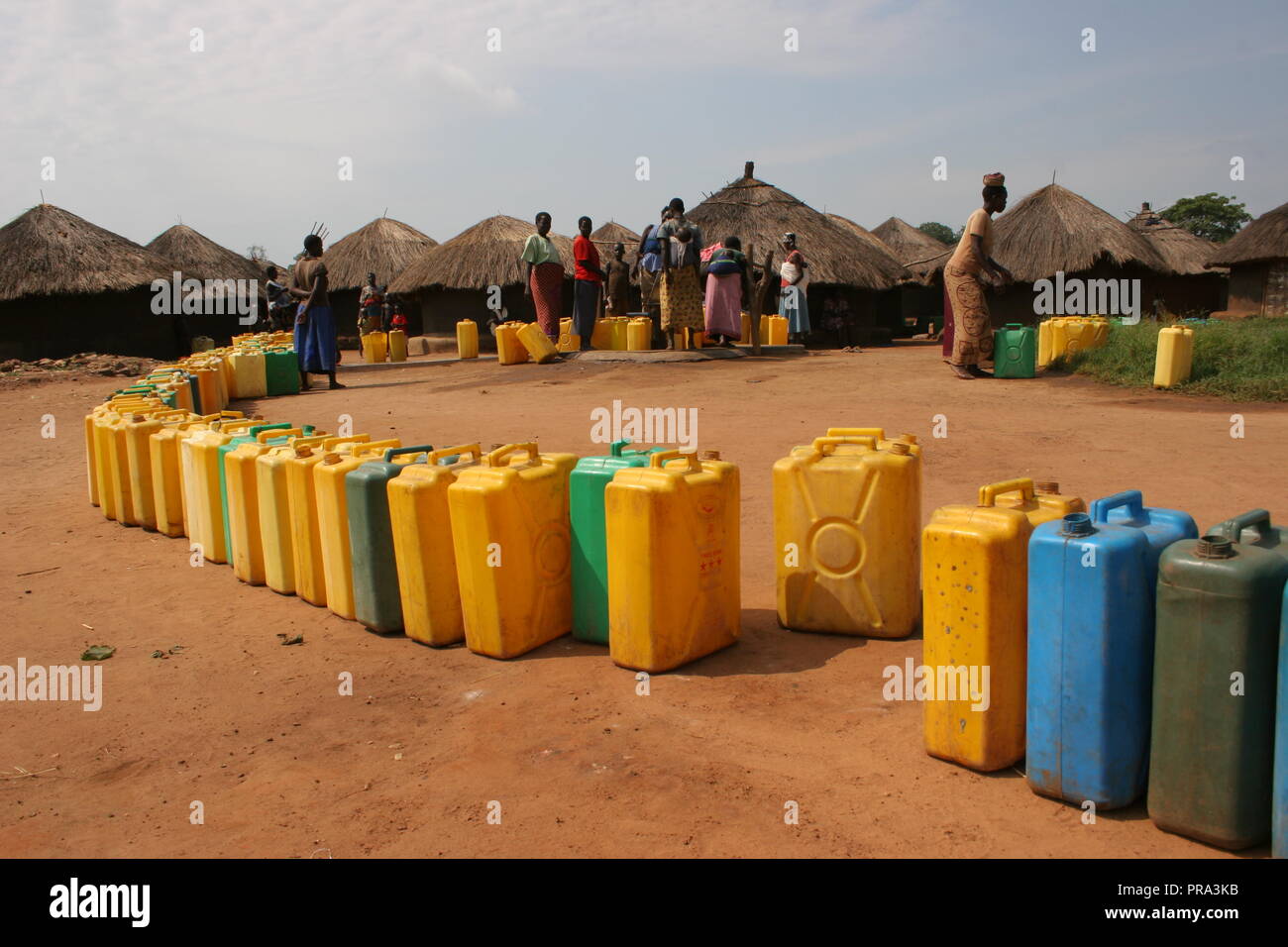 Una lunga linea di bidoni di aspettare di essere riempito in un singolo foro di trivellazione di acqua ad Atiak Persone Internamente Sfollate (IDP) camp, Uganda settentrionale. Foto Stock