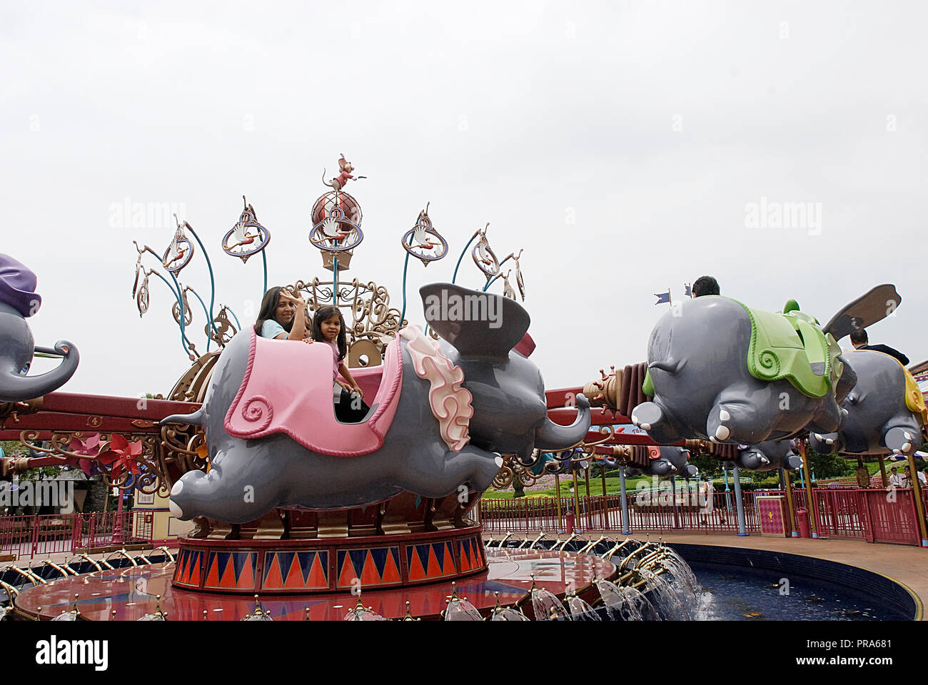 Madre e figlia facendo un giro sul DUMBO IL FYLING ELEFANTE A HONG KONG DISNEYLAND Foto Stock