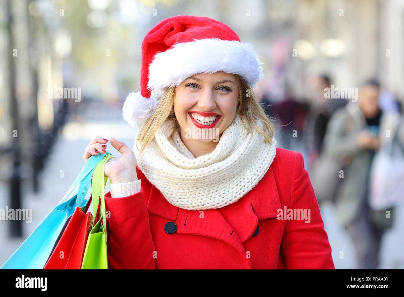 Vista anteriore verticale di un felice shopper tenendo le borse della spesa in posa la strada a chritmas vacanze Foto Stock