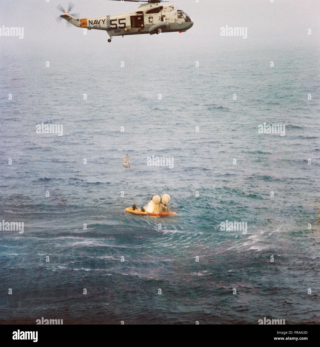 Un membro dell'Apollo 7 equipaggio è issato fino al ripristino di un elicottero a bordo della USS Essex durante le operazioni di ripristino. L' Apollo 7 veicoli spaziali spruzzato verso il basso a 7:11 a.m., Ottobre 22, 1968, circa 200 miglia nautiche a sud-sud-ovest di Bermuda. Photo credit: la NASA Foto Stock