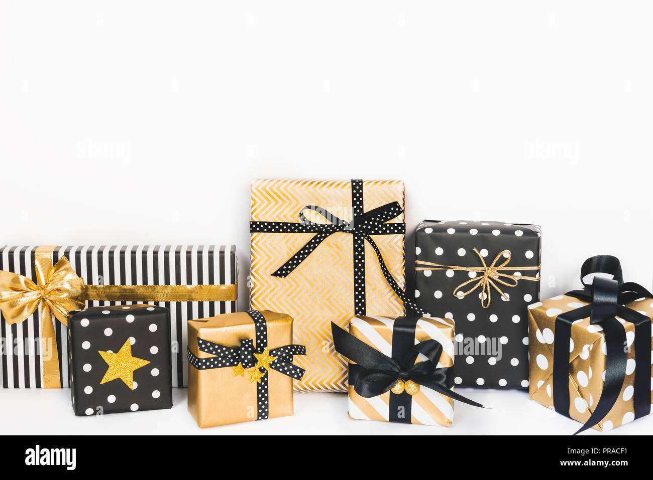 Vista frontale delle scatole regalo in vari nero, bianco e disegni dorati. Copia dello spazio. Un concetto di Natale, Capodanno, Festa di compleanno evento. Foto Stock