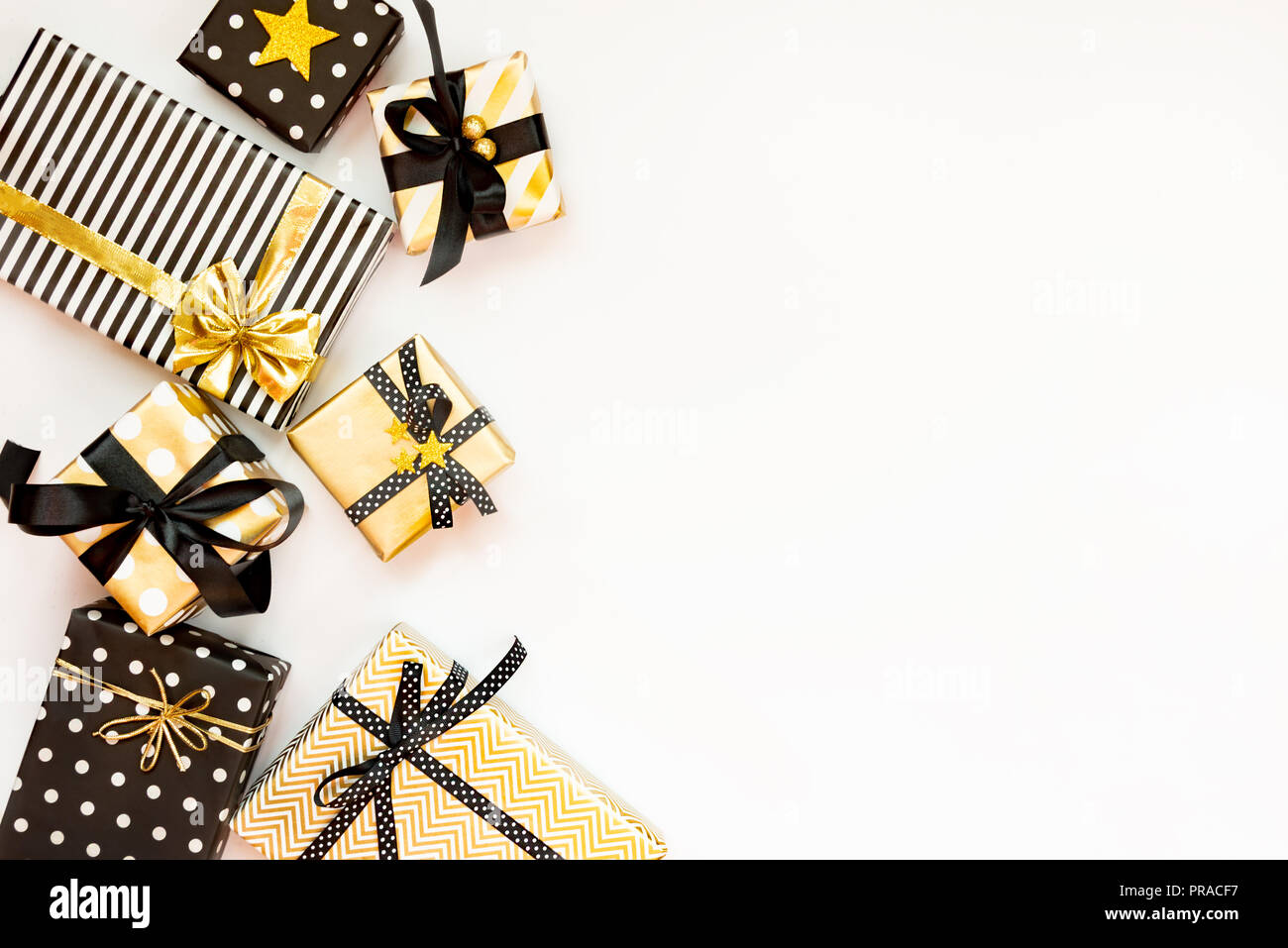 Vista superiore delle confezioni regalo in vari nero, bianco e disegni dorati. Laici piana, copia dello spazio. Un concetto di Natale, Capodanno, Festa di compleanno evento. Foto Stock