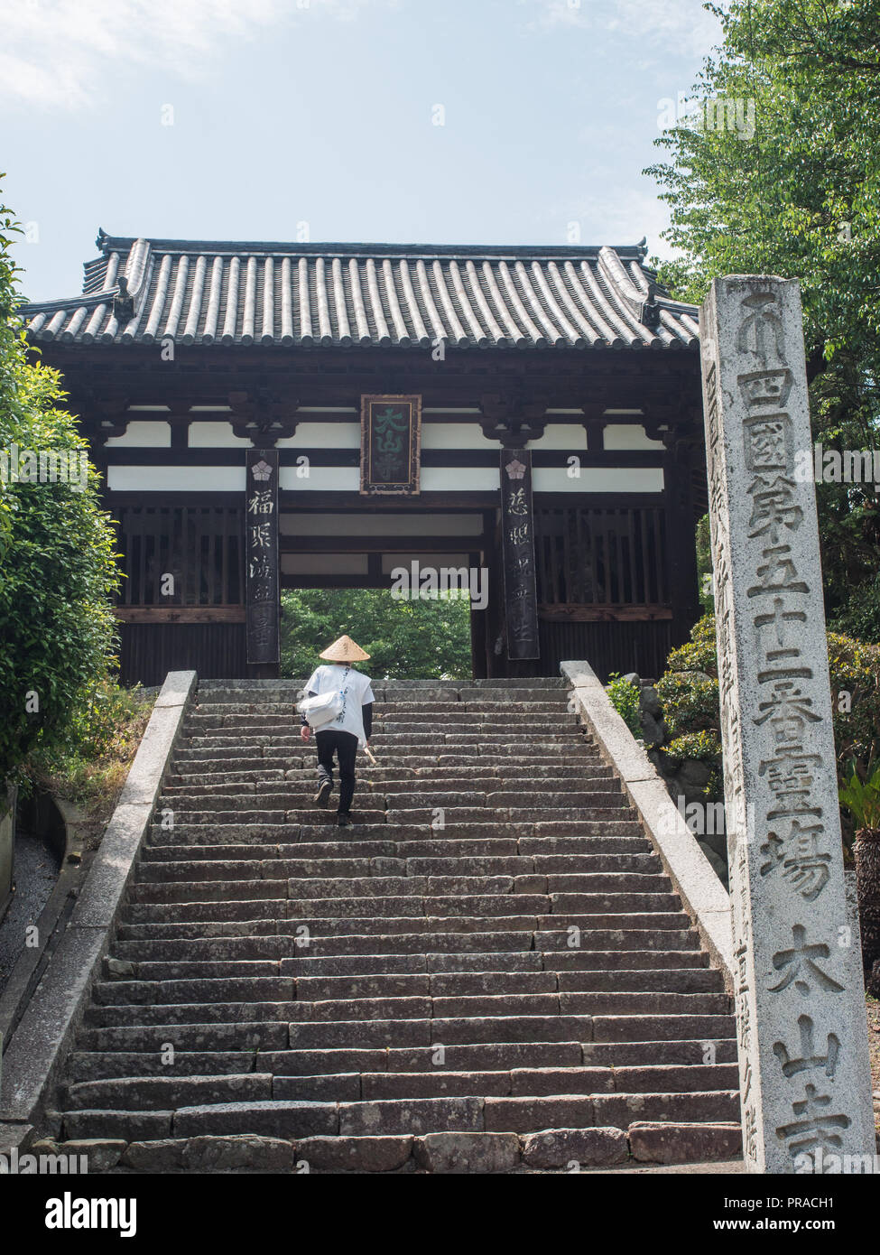 Pellegrino Henro salite passi a gatehouse, tempio Taisanji 52, Shikoku 88 Tempio pellegrinaggio, Ehime in Giappone. Foto Stock