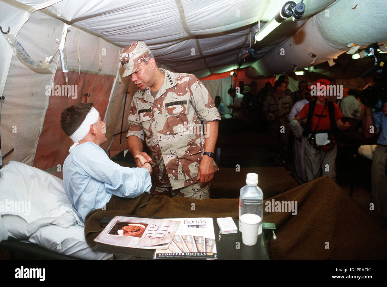 General Colin Powell, presidente del Comune di capi di Stato Maggiore, parla con un paziente con un campo struttura medica durante operazione Desert Shield. Foto Stock