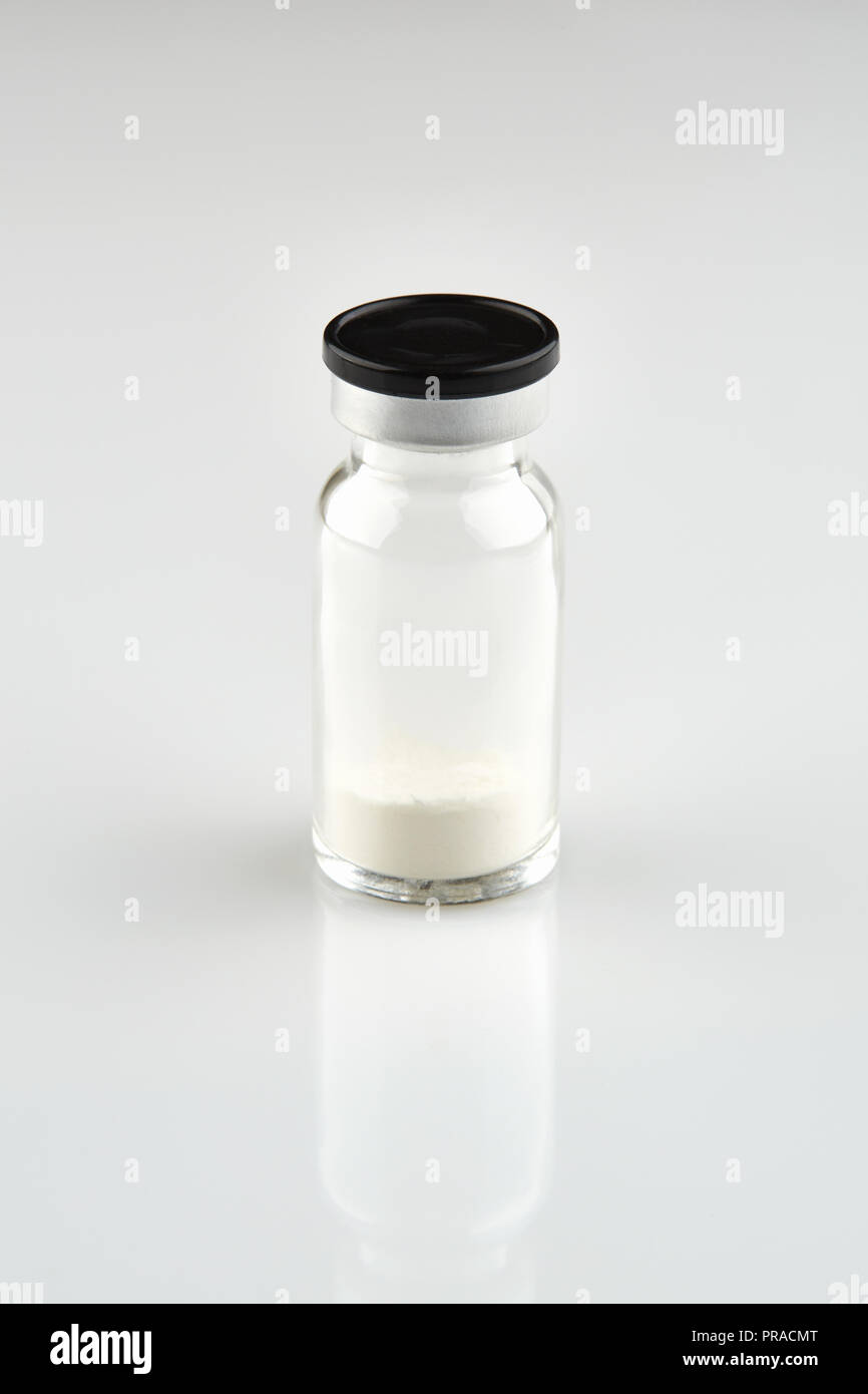 Piccola bottiglia sigillata con la medicina su sfondo bianco. Foto Stock