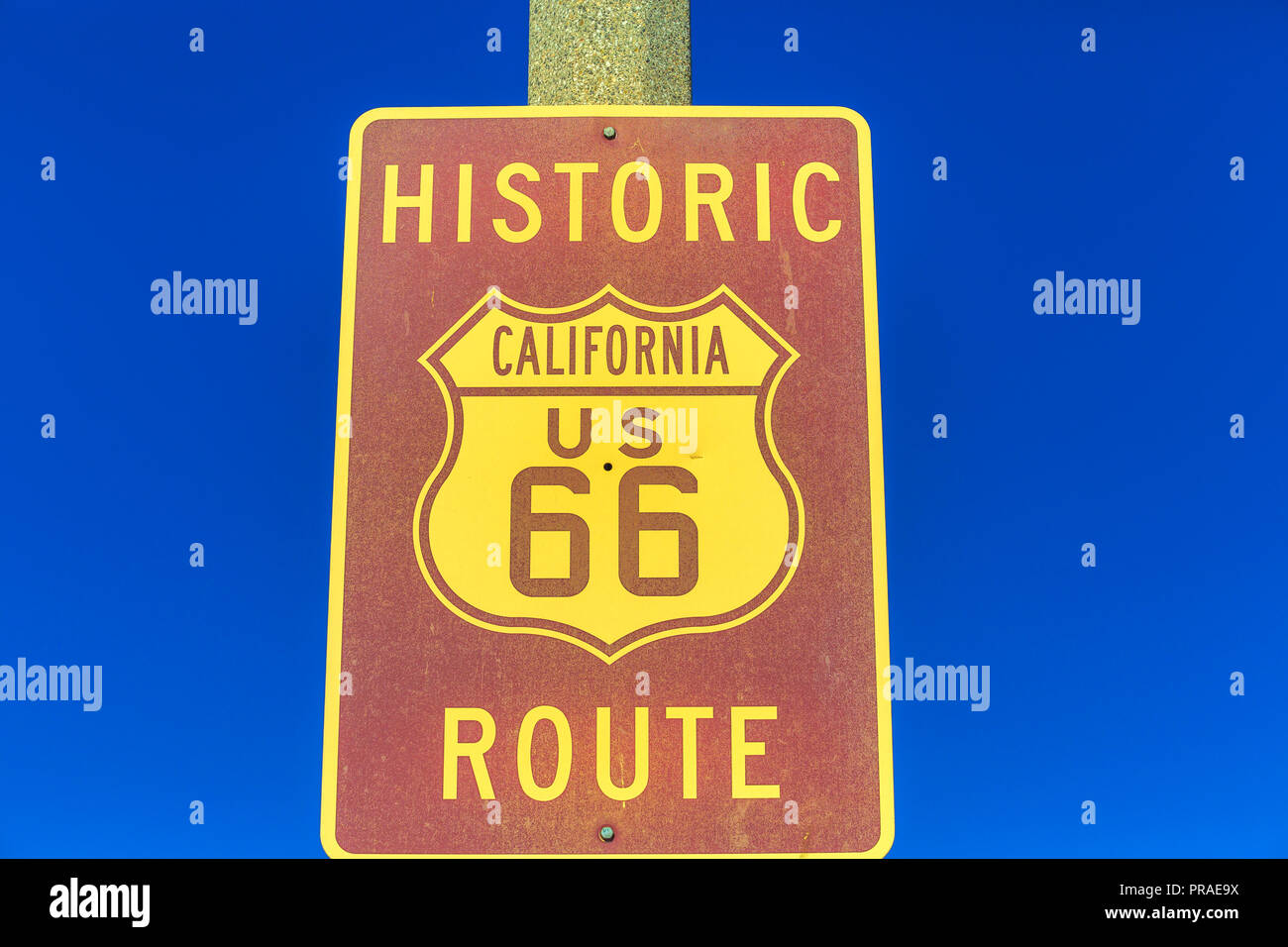 Primo piano della storica Route 66 cartello stradale lungo la via principale di Barstow, California sul cielo blu. Famosa strada Madre o sessanta sei segno. Foto Stock