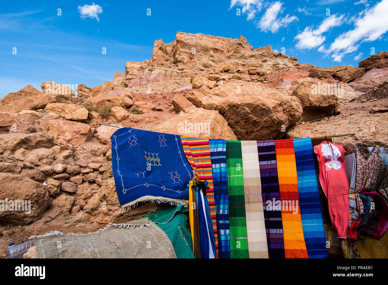 Tradizionali tappeti marocchini e il rosso delle rocce e delle pietre in background Foto Stock