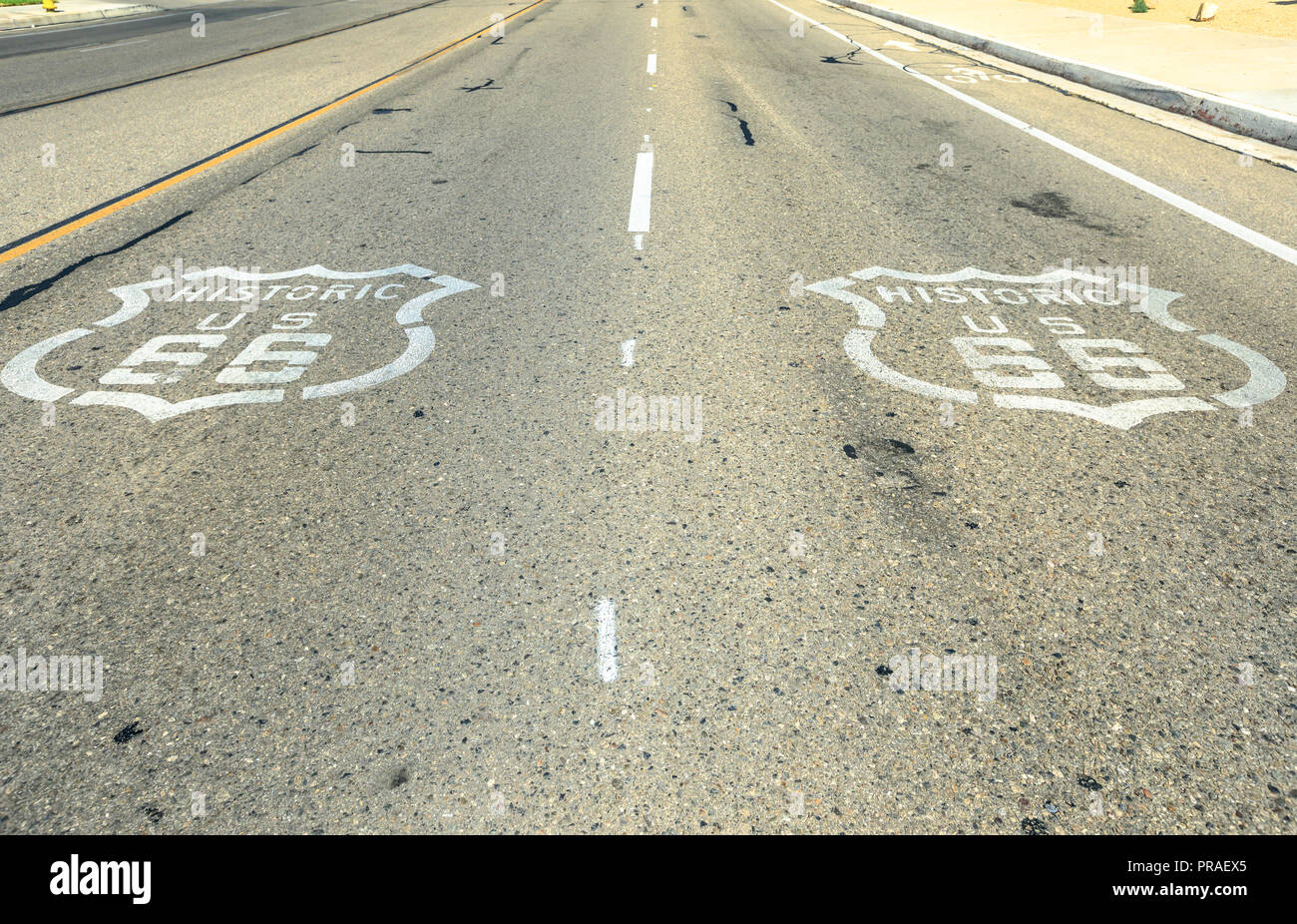 Pavimentazione strada segno sulla storica Route 66 in Barstow, Mojave Desert. Madre strada o sessanta sei sfondo. Route 66 autostrada con segno su asfalto. Foto Stock