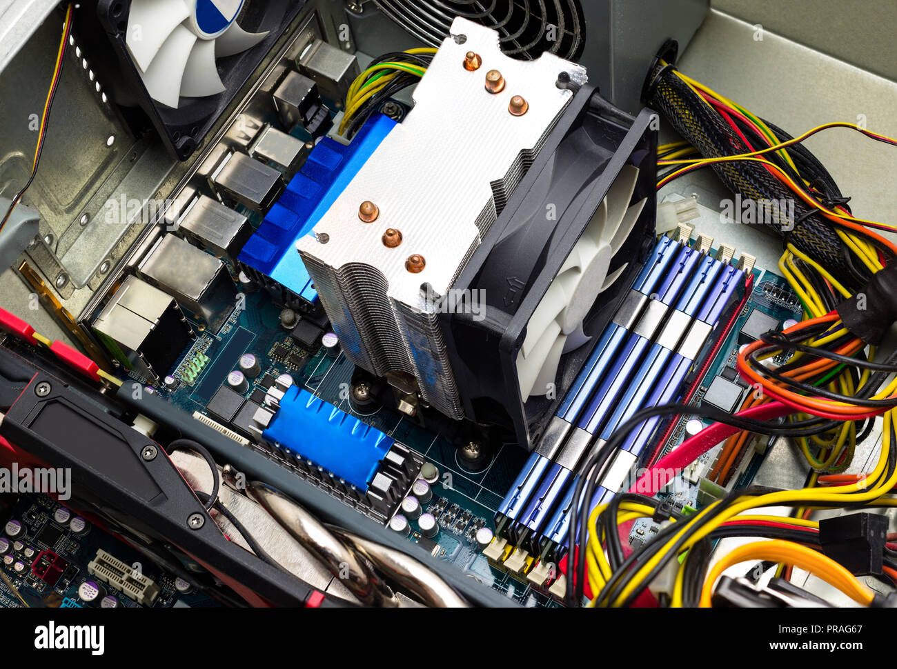 La scheda madre del computer vista superiore visibile il dissipatore di calore e ventola, memoria RAM, scheda video, alimentazione e cavi. Foto Stock