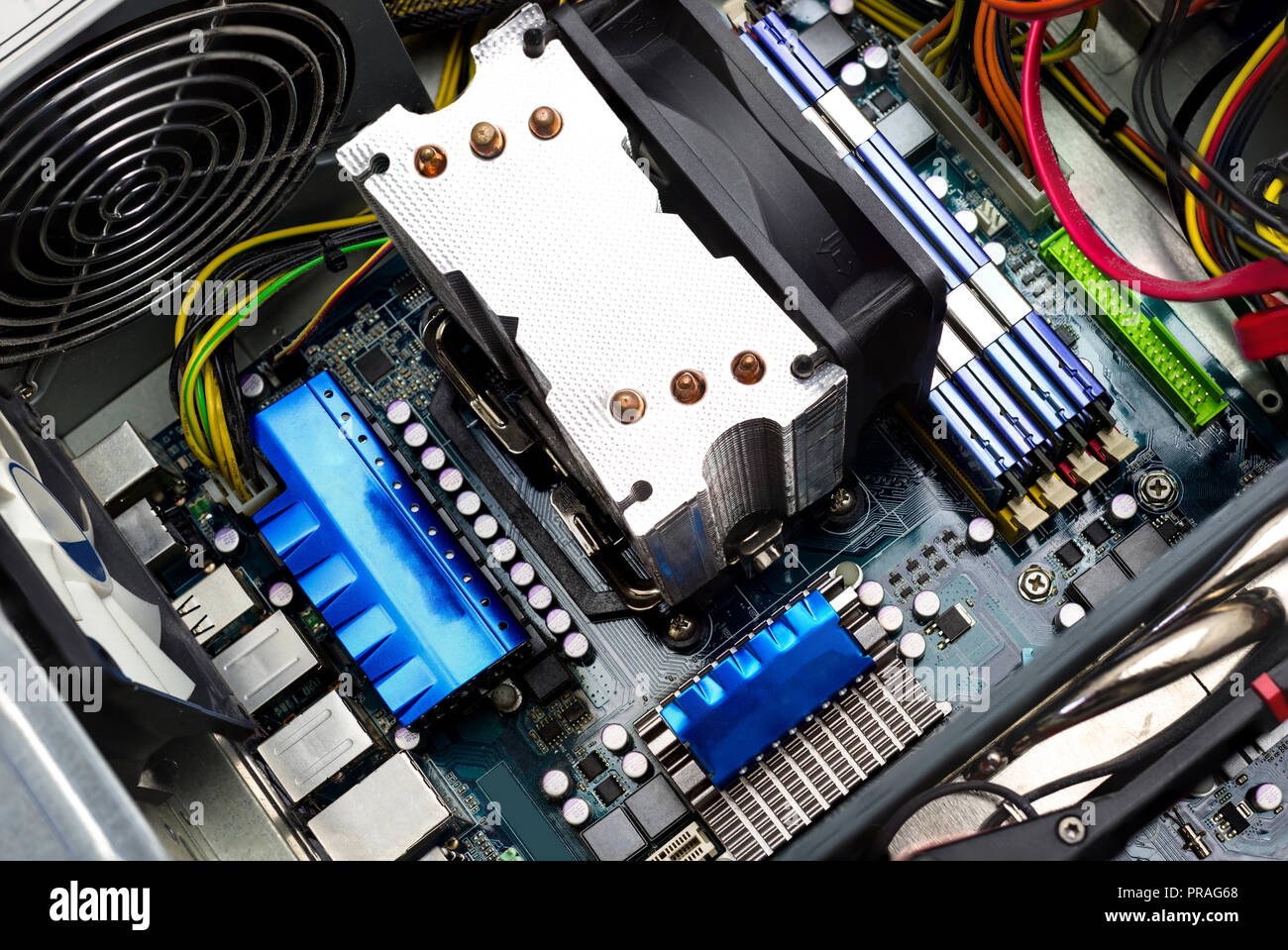 La scheda madre del computer vista superiore visibile il dissipatore di calore e ventola, memoria RAM, scheda video, alimentazione e cavi. Foto Stock