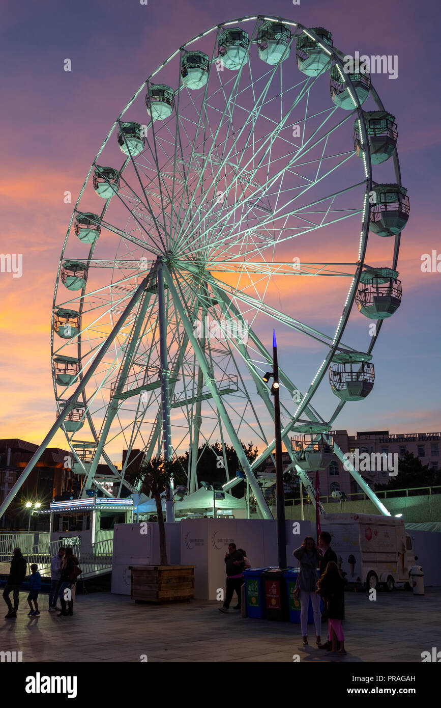 Fiera ruota panoramica Ferris al Molo approccio, Bournemouth Dorset, Regno Unito sotto una rosa e azzurro cielo di tramonto. Foto Stock