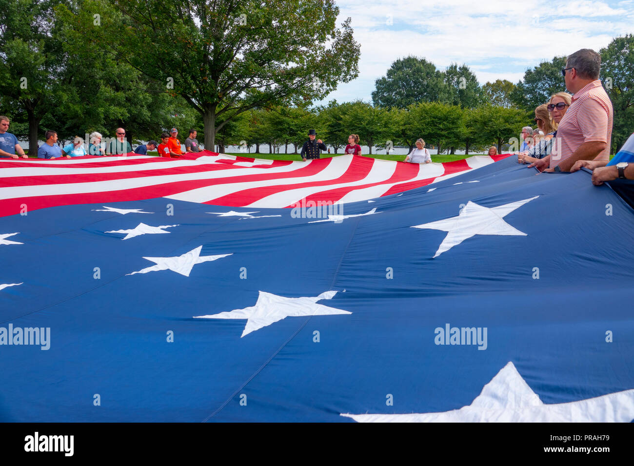 Stati Uniti Maryland MD Baltimore Fort McHenry visitatori tenere un grande replica della bandiera che stava volando quando Francis Scott Key ha scritto la poesia inno Foto Stock