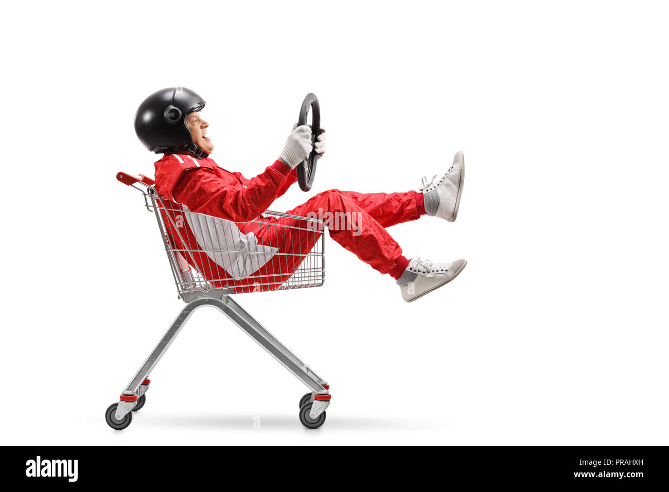 Uomo anziano in una tuta racing con casco tenendo un volante e seduta all'interno di un carrello isolato su sfondo bianco Foto Stock