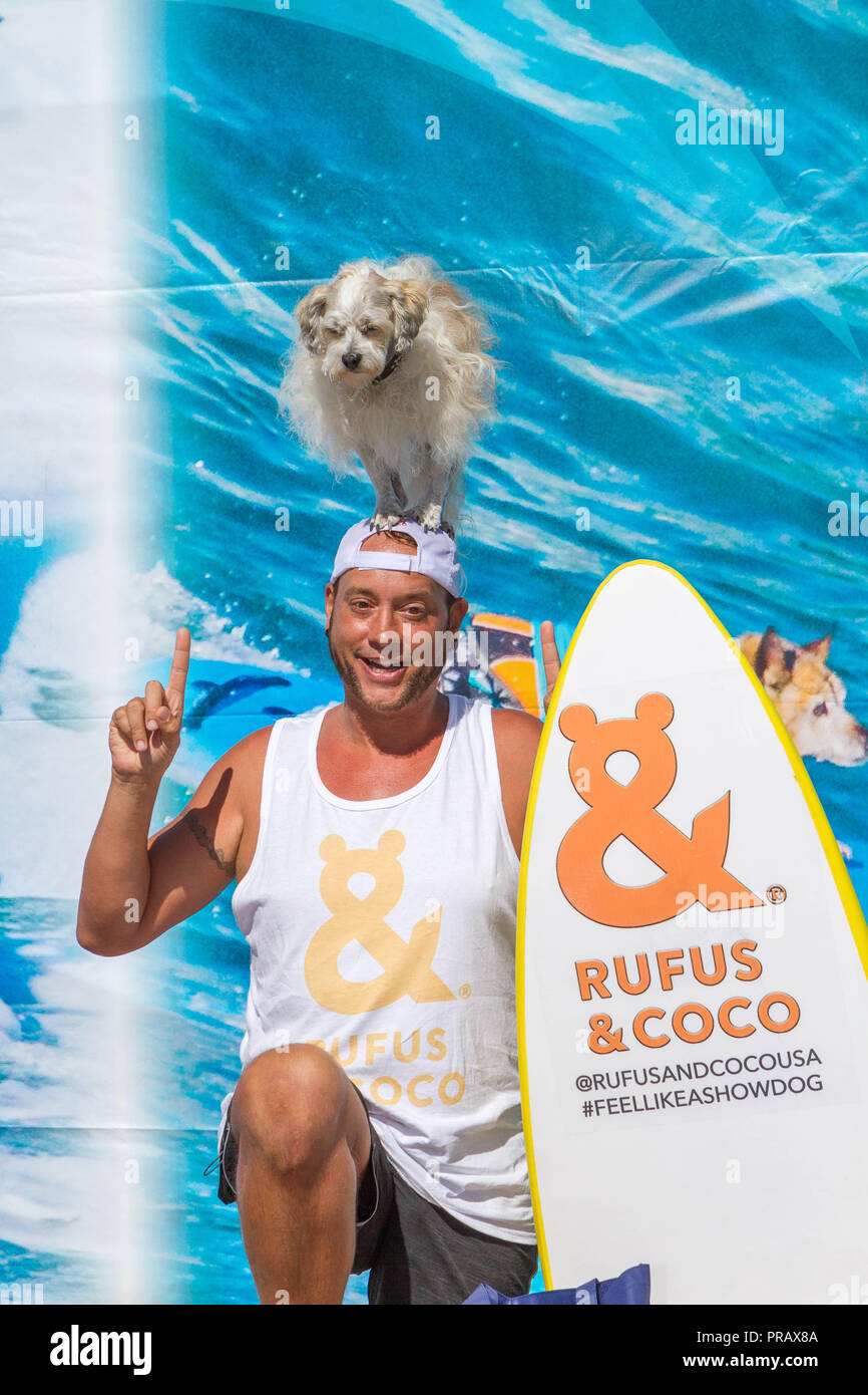Hunnington Beach, CA, Stati Uniti d'America. 29Sep, 2018. Surfcity Surfdog concorrenza. La McKenna Subaru Surf City Surf cane", il famoso premier evento sul cane circuito Surf è tenuto ogni anno a fine settembre nel Surf City USA. L'evento riunisce le comunità, i surfisti e gli amanti del cane, famiglie & animali domestici per una giornata di divertimento e raccolta fondi a uno della California del sud più incontaminate spiagge - Huntington Dog Beach! .Visto qui:Ryan Thor e il suo cane Prince Dudeman dopo aver preso prima nella divisione VI. Credito: Daren Fentiman/ZUMA filo/Alamy Live News Foto Stock