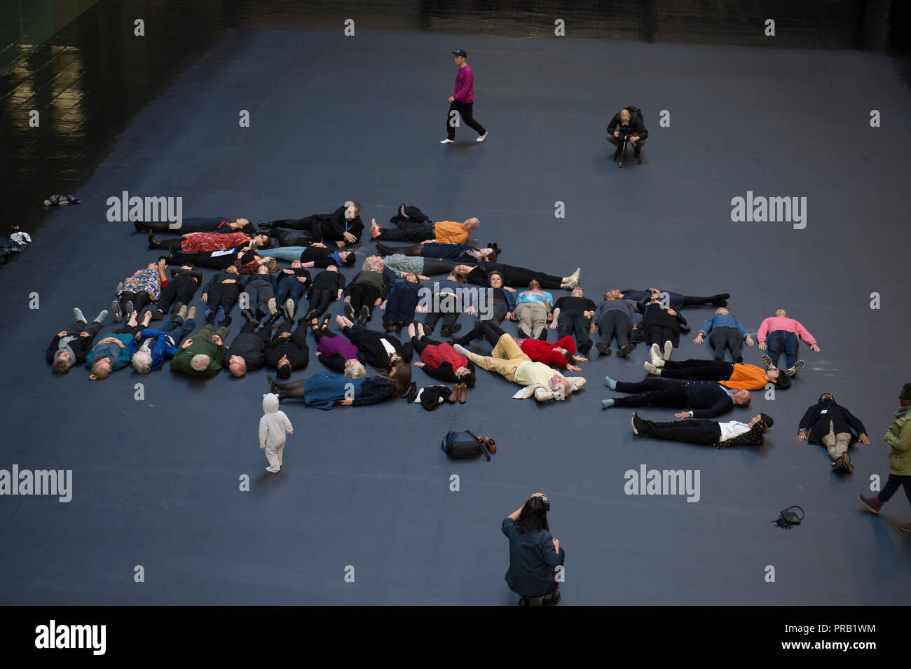 Tate Modern, Turbine Hall di Londra, Regno Unito. 1 Ottobre, 2018. Artista cubana Tania Bruguera la grande commissione per la Tate Modern di turbina della Hall, parte della Hyundai serie della Commissione. Il Turbine Hall è coperto in un apparentemente normale pavimento nera al di sotto del quale è nascosta una grande immagine raffigurante il volto di un giovane uomo che ha lasciato la Siria nel 2011. I visitatori possono provare a rivelare questa immagine attraverso l azione collettiva, toccando il calore sensibile piano per tentare di rivelare l'immagine sottostante. Credito: Malcolm Park/Alamy Live News. Foto Stock