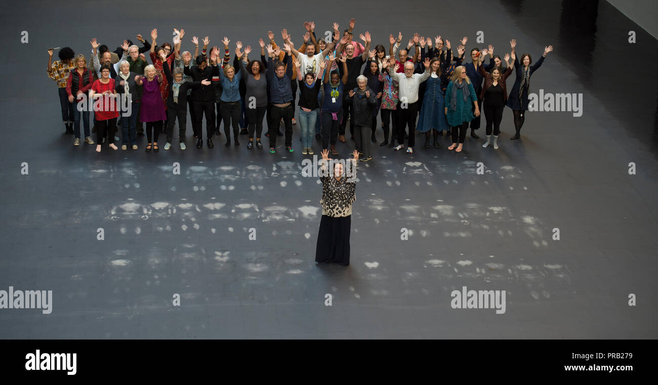 Tate Modern, Turbine Hall di Londra, Regno Unito. 1 Ottobre, 2018. Artista cubana Tania Bruguera accanto ai suoi grandi commissione per la Tate Modern di turbina della Hall, parte della Hyundai serie della Commissione. Il Turbine Hall è coperto in un apparentemente normale pavimento nera al di sotto del quale è nascosta una grande immagine raffigurante il volto di un giovane uomo che ha lasciato la Siria nel 2011. I visitatori possono provare a rivelare questa immagine attraverso l azione collettiva, toccando il calore sensibile piano per tentare di rivelare l'immagine sottostante. Credito: Malcolm Park/Alamy Live News. Foto Stock