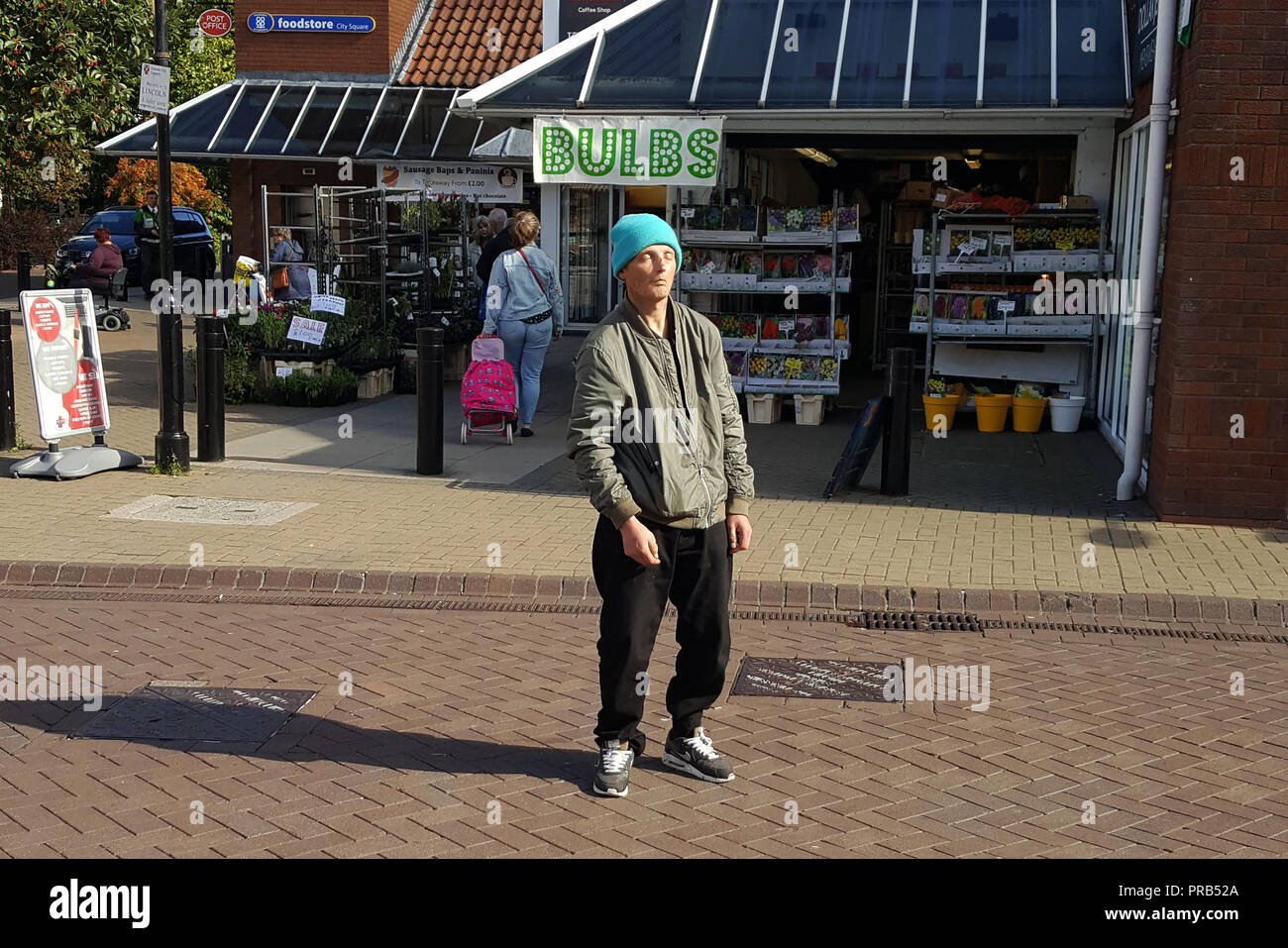 Candida immagine presa su uno smartphone di street photography. Un uomo senza tetto eventualmente sotto l'influenza di 'Spice' Foto Stock