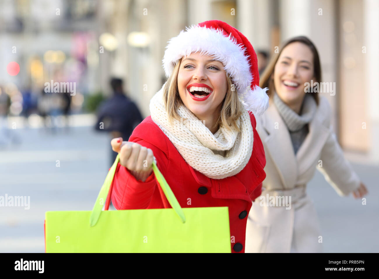 Due amanti dello shopping shopping sacchetti di contenimento in esecuzione ricerca negozi all'aperto sulla strada Foto Stock