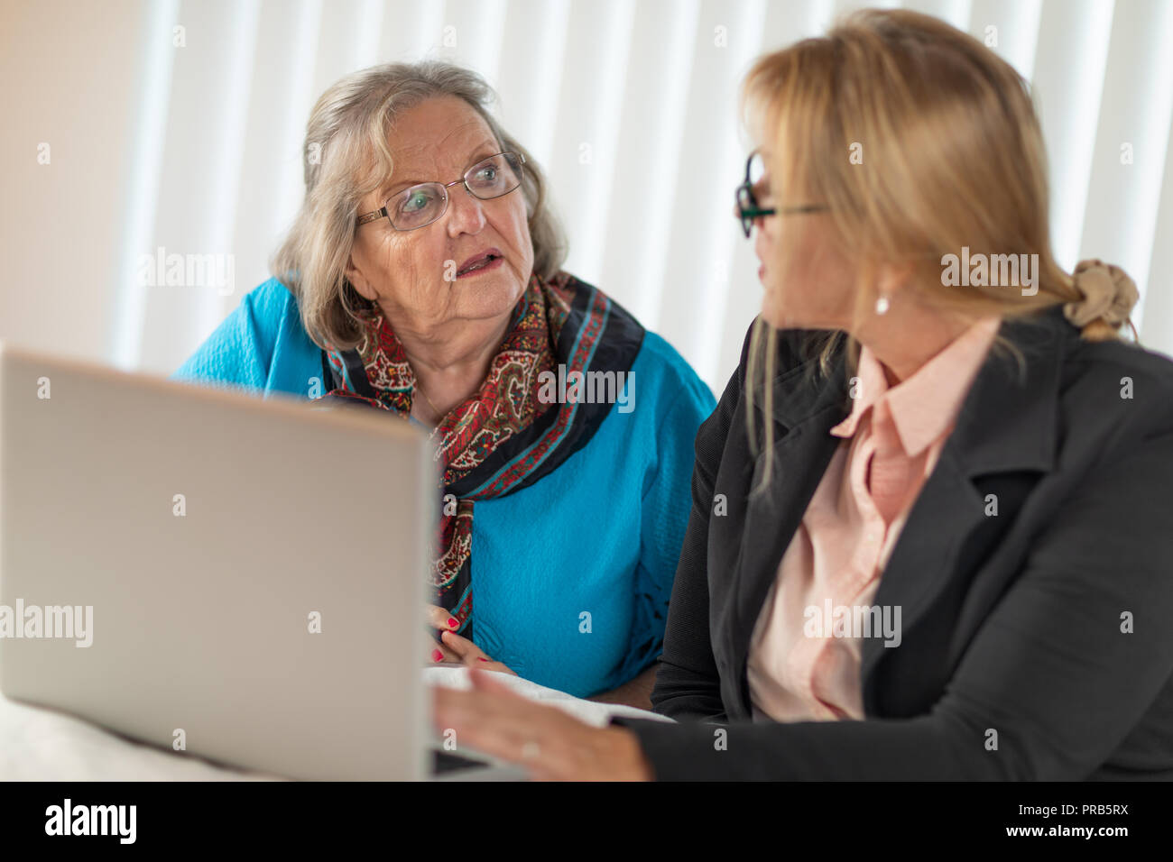 La donna aiuta adulti Senior Lady sul computer portatile. Foto Stock