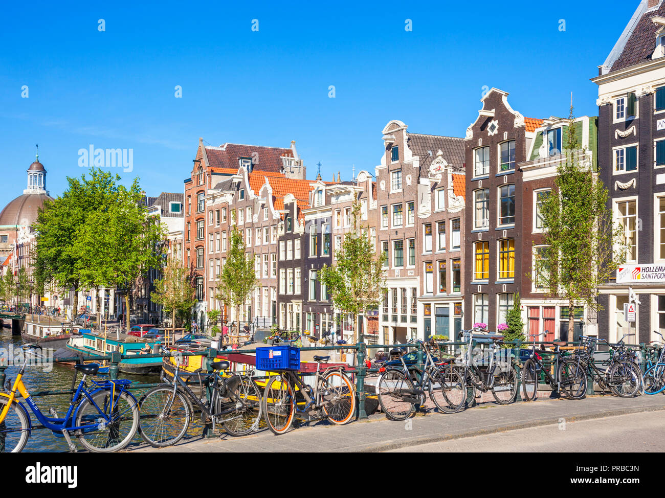 Case di Amsterdam e biciclette sul Singel un canale di Amsterdam Blauwburgwal ponte sul canale Singel amsterdam noleggio sostennero contro le ringhiere Amsterdam UE Foto Stock