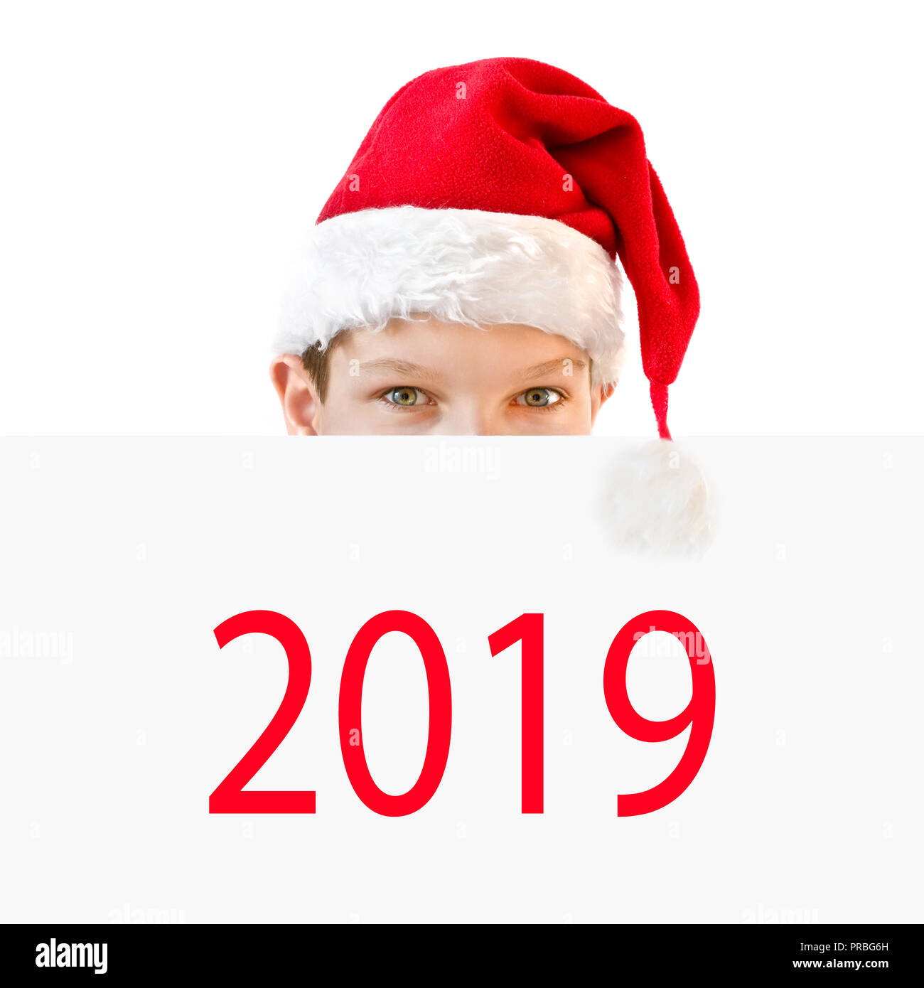Giovane ragazzo in rosso Santa hat nascondersi dietro un pannello 2019 Foto Stock