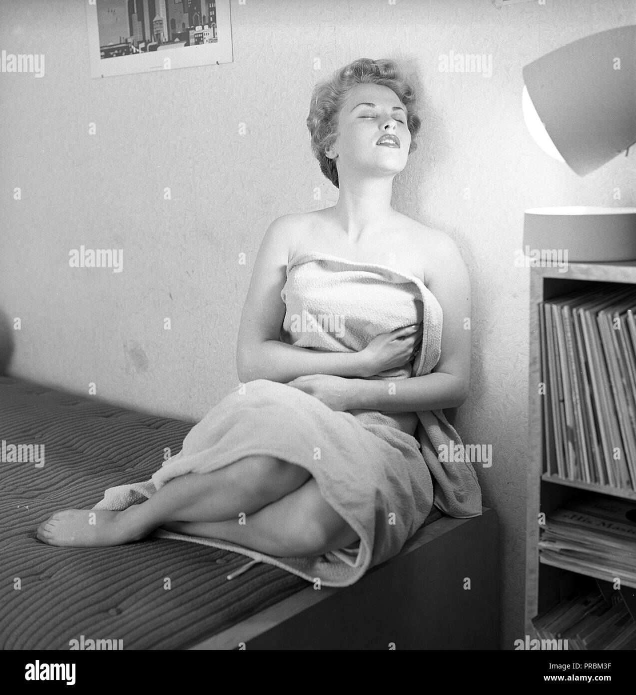 Cura di bellezza negli anni cinquanta. Una giovane donna è ottenere una abbronzatura dalla luce solare artificiale dalla home la concia lampada abbronzante. Un dispositivo che ha dato un tan e talvolta era un trattamento per malattie. Nella foto il cantante Bibi Johns nato 1929. La Svezia 1954. Ref 2666 Foto Stock