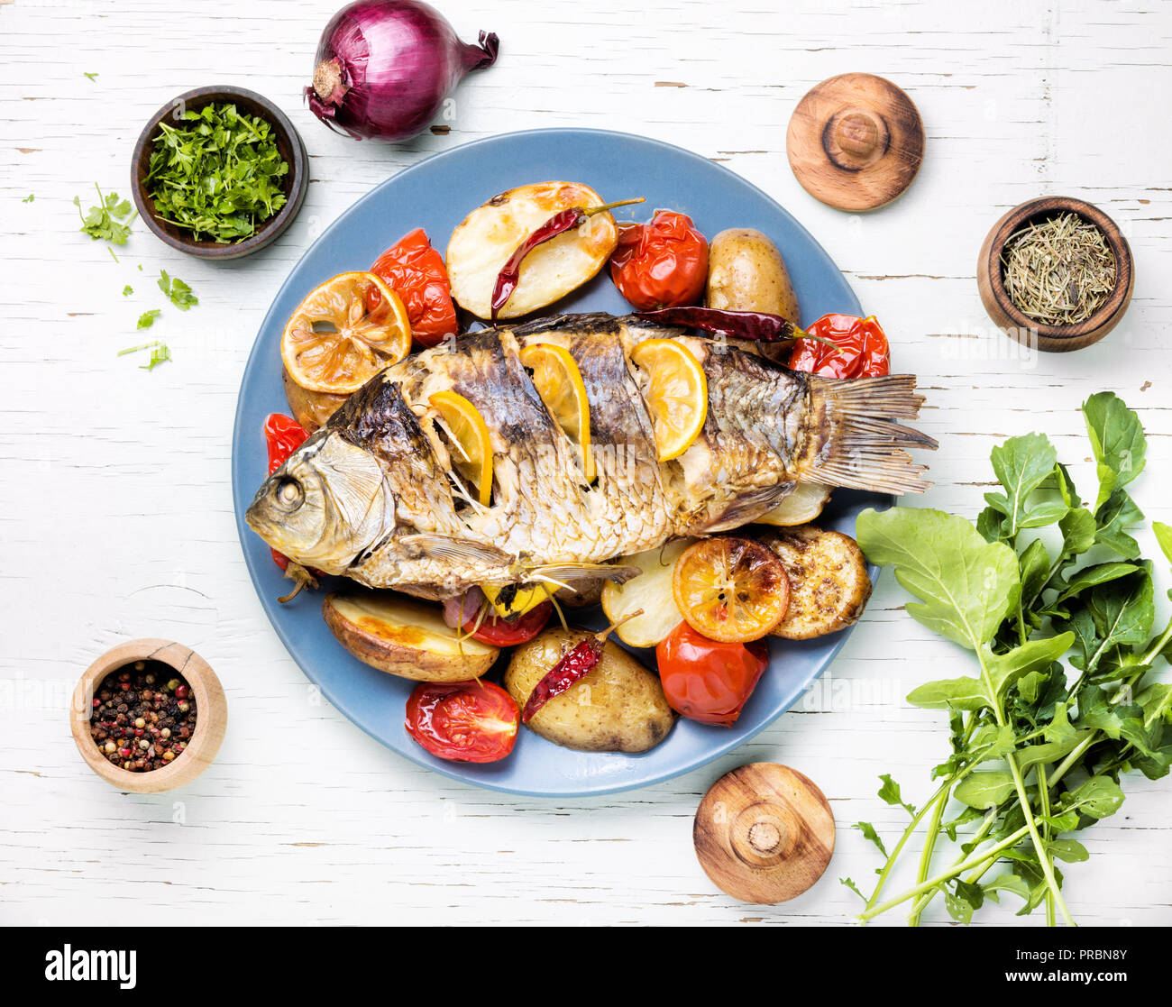 Pesce alla griglia con patate arrosto e verdure sulla piastra Foto stock -  Alamy