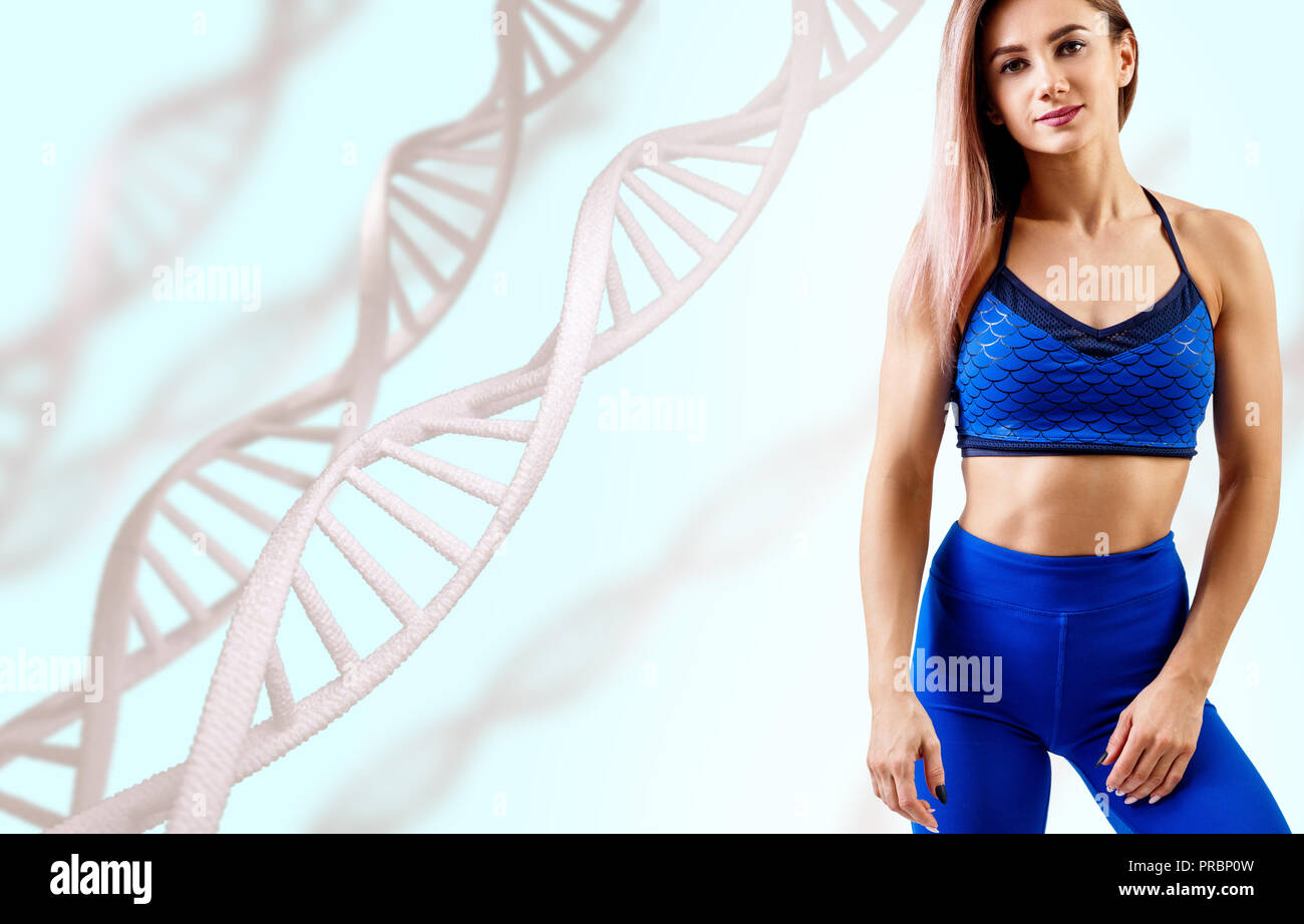 Giovane donna con il corpo atletico in piedi tra le catene di DNA. Foto Stock