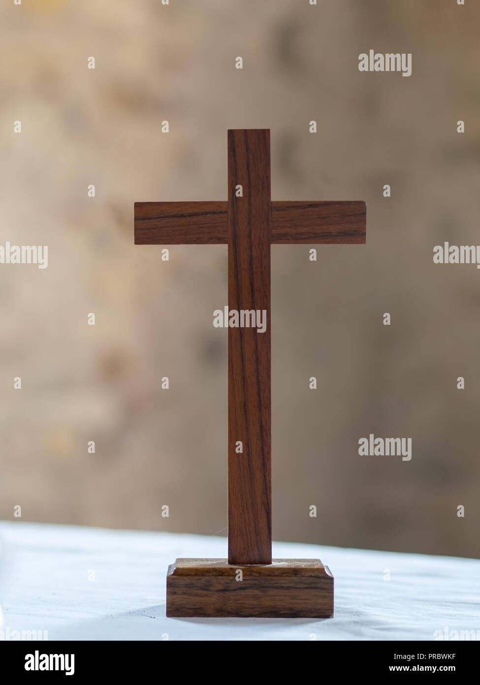 Croce di legno sul bianco panno altare dello sfondo. La fede cristiana. Foto Stock