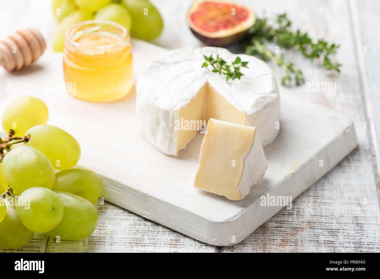 Il piatto di formaggi con brie, camembert, miele e frutti, vista ravvicinata, il fuoco selettivo. Antipasto Gourmet piastra Foto Stock