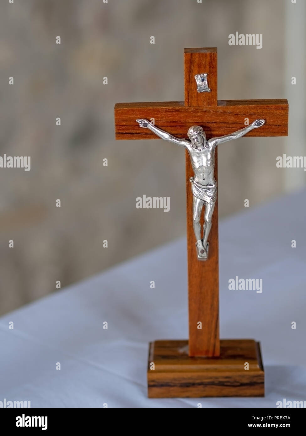 Crocifisso ligneo sull altare bianco sullo sfondo di stoffa. La fede cristiana. Foto Stock